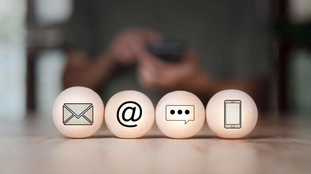 alt="Image décorative représentant 4 billes en bois avec dedans une enveloppe, un arobase, une bulle de discussion et un téléphone."